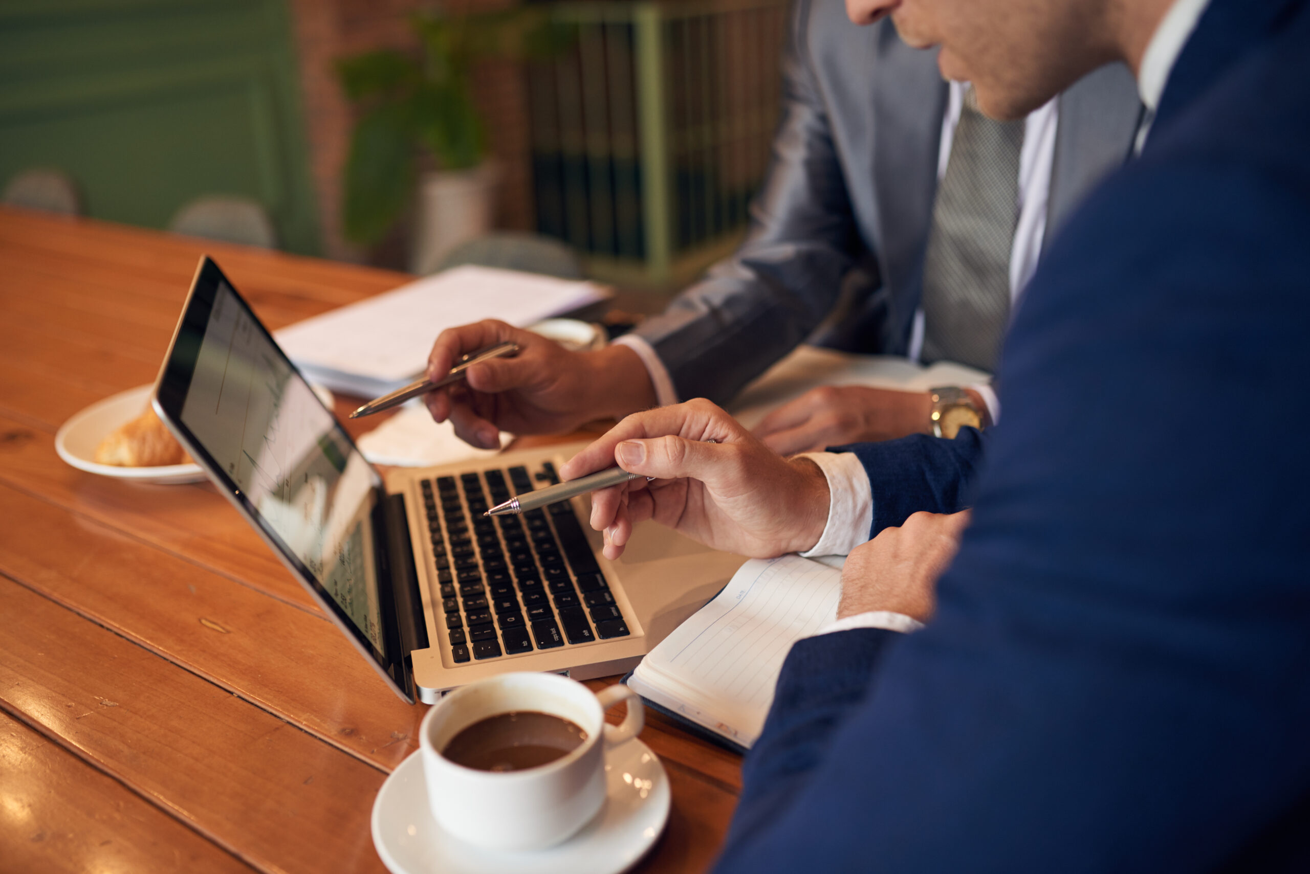 Business people analyzing statistics on laptop screen, selective focus