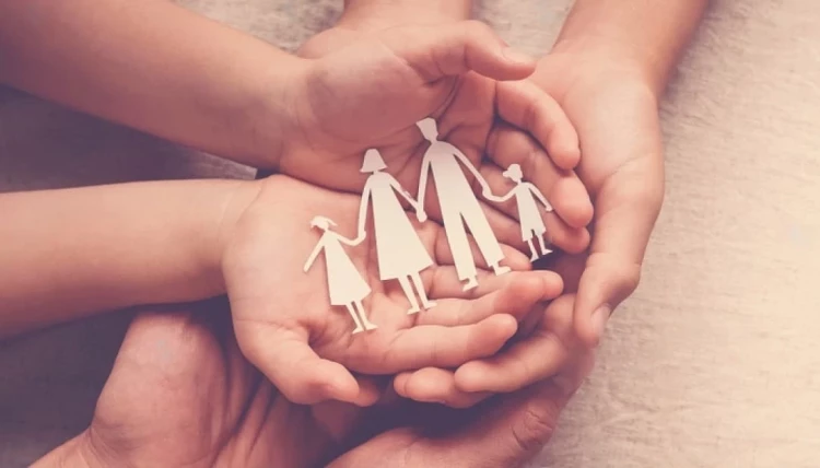 stock-photo-hands-holding-paper-family-cutout-family-home-foster-care-homeless-support-world-mental-1-750x428